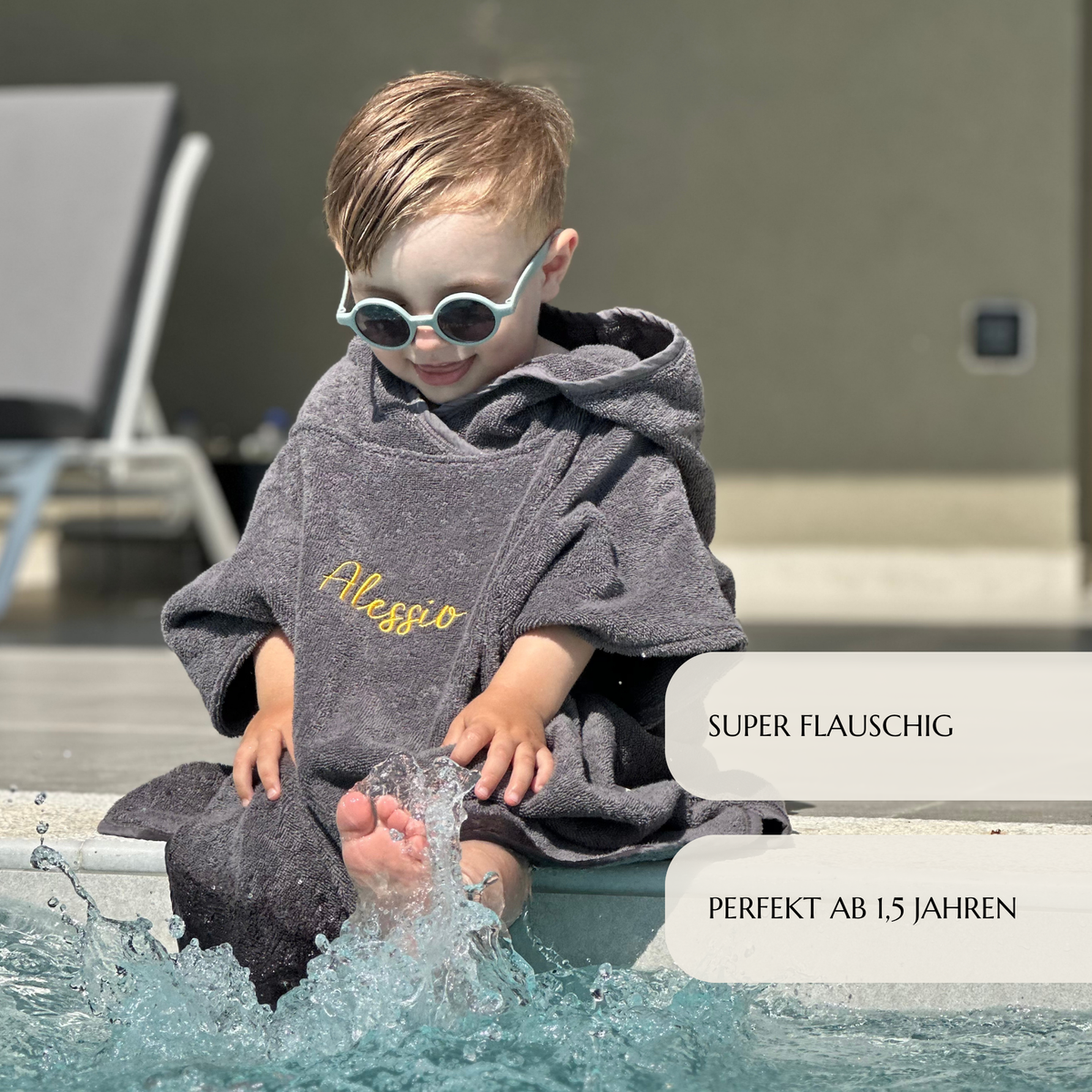 Kind im Badeponcho anthrazit am Pool