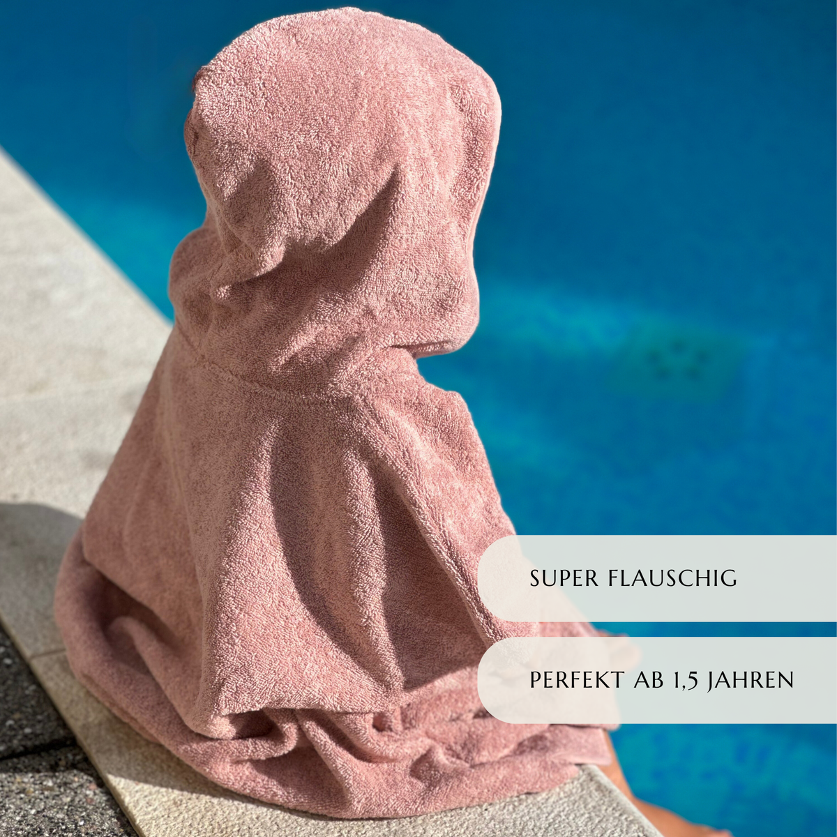Kind im rosa Badeponcho am Strand